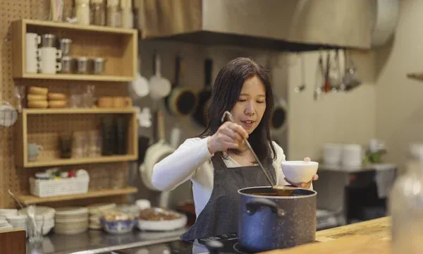 厨房でスープをよそうKEIPEの飲食スタッフ
